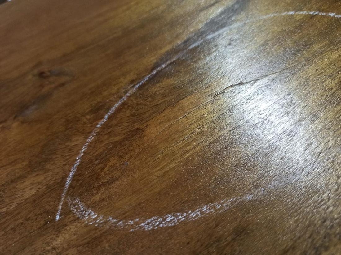 Crack in the wood of a cabinet, circled in chalk by the inspector.