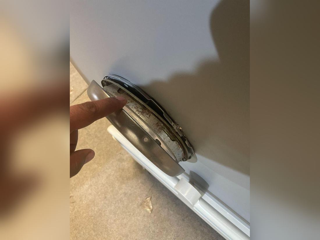 Round light fitting on the front of a bar cabinet that was not fitted correctly, recorded at a pre-shipment inspection in Jodhpur.