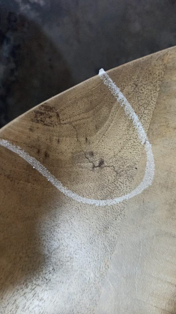 Fine cracks around a knot near the edge of a grey-finished top