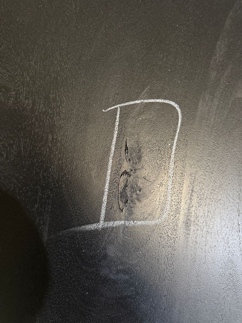 Cracked, open knot in a black-finished top, boxed in chalk