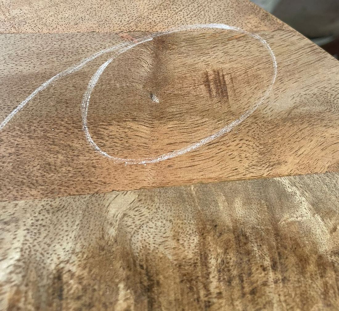 Dent in a dining table top, circled by the inspector