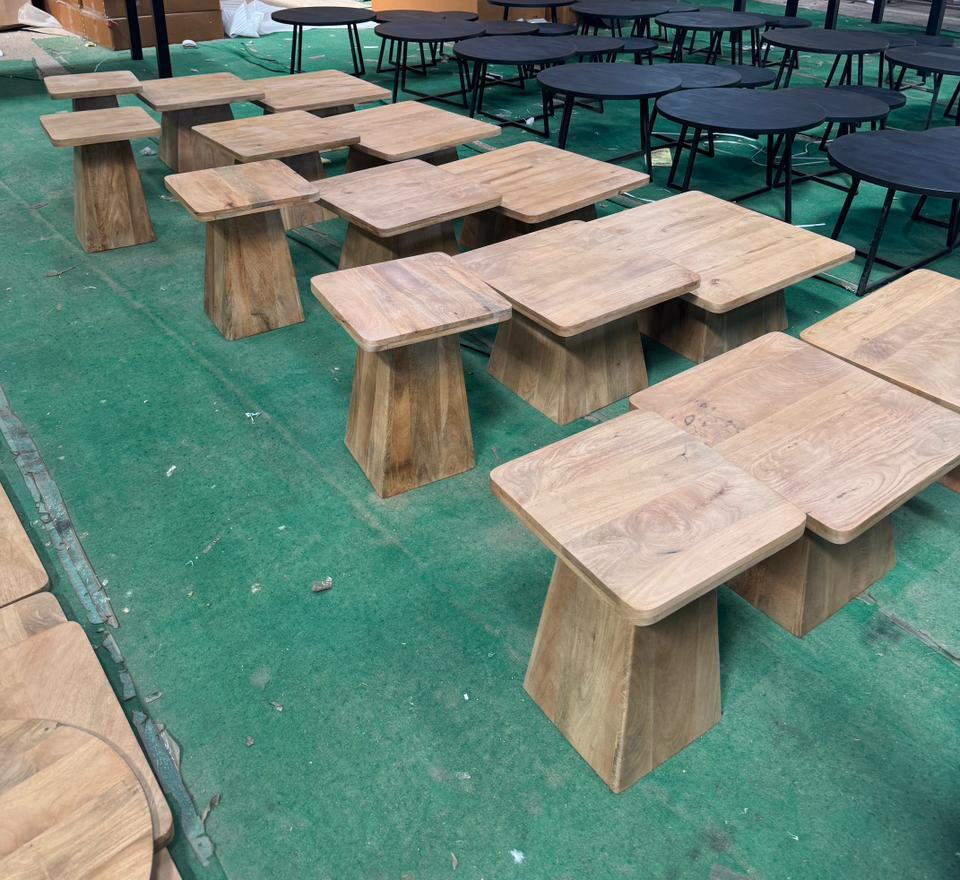 Square side tables on solid wood pyramid bases laid out for checking