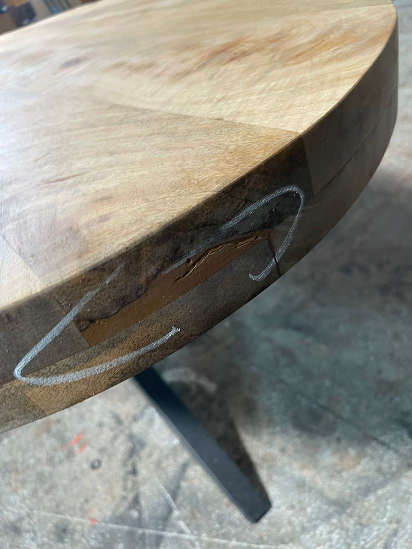 Split and a patched section in the edge of a thick round top
