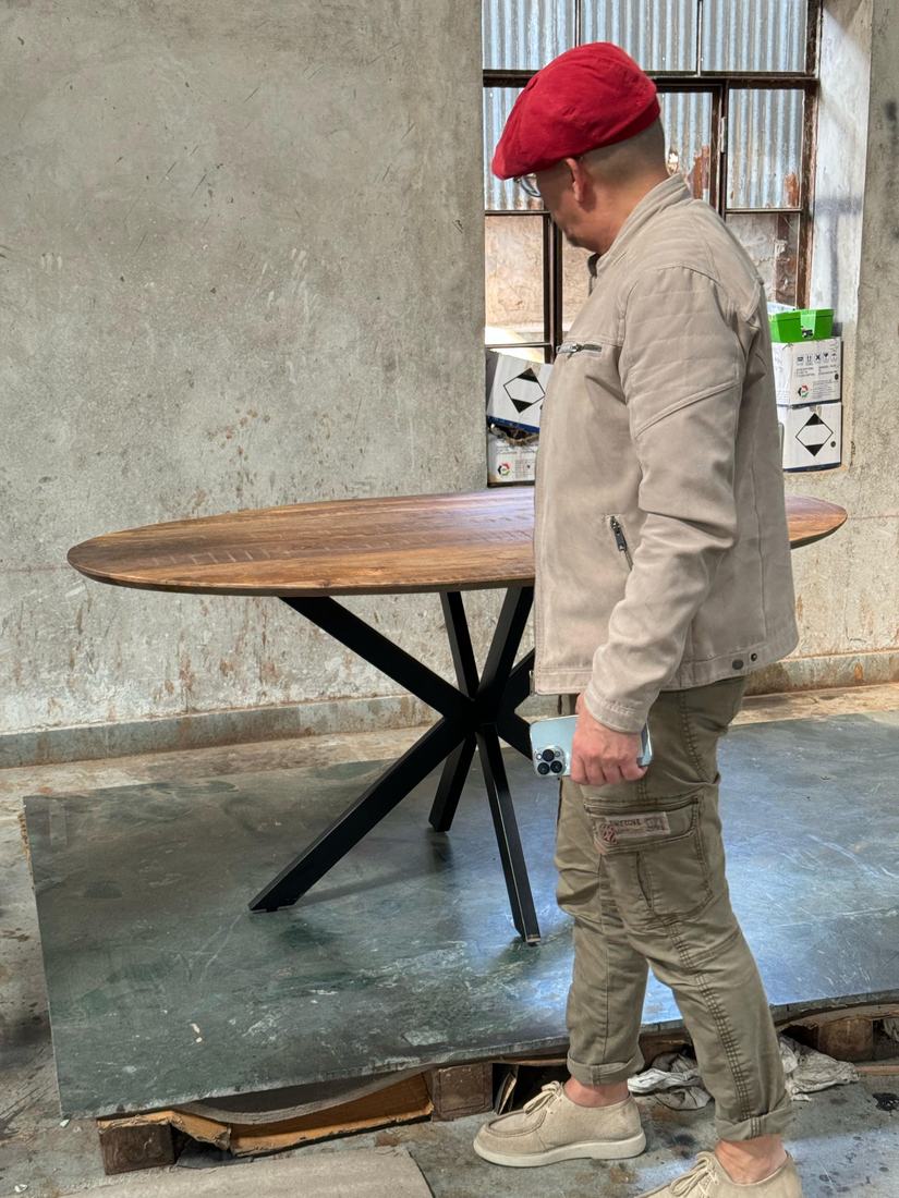 Oval dining table on a metal star base, reviewed with the buyer