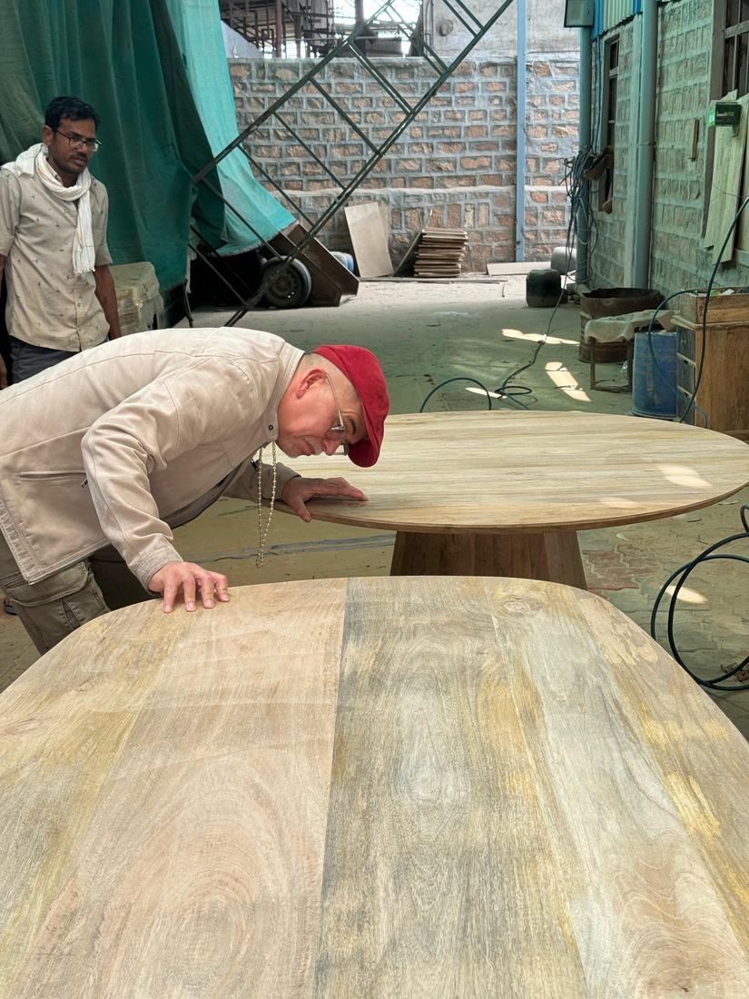 Sighting along a table top for flatness with the buyer at the factory
